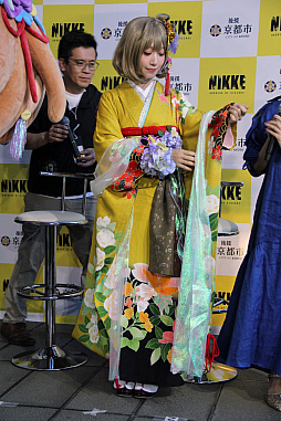 画像ギャラリー No.018のサムネイル画像 / 「勝利の女神：NIKKE」が京都各地をめぐる街歩き企画を開始。黄色に染まるタワーの前で声優らが参加を呼びかけた